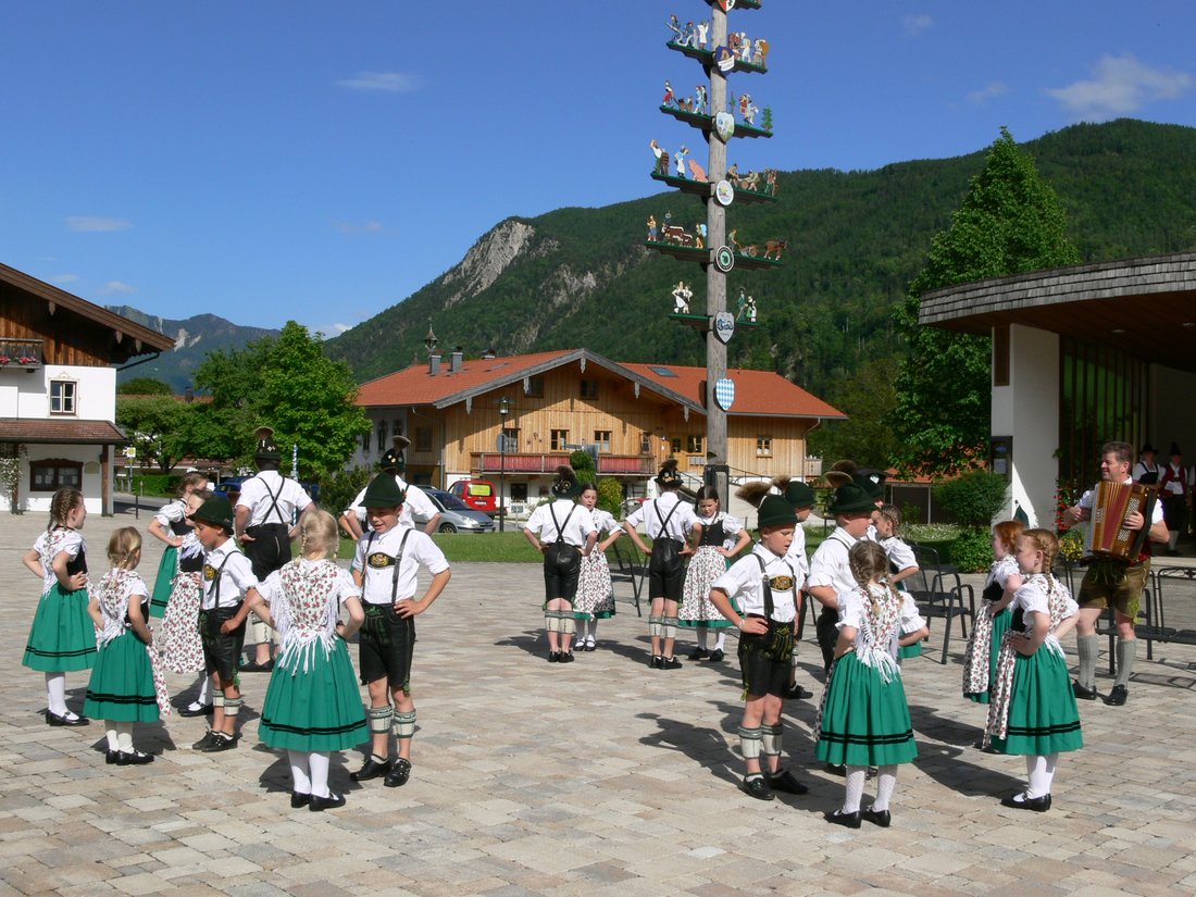 Die Trachtler von Schleching tanzen am Dorfplatz der Gemeinde