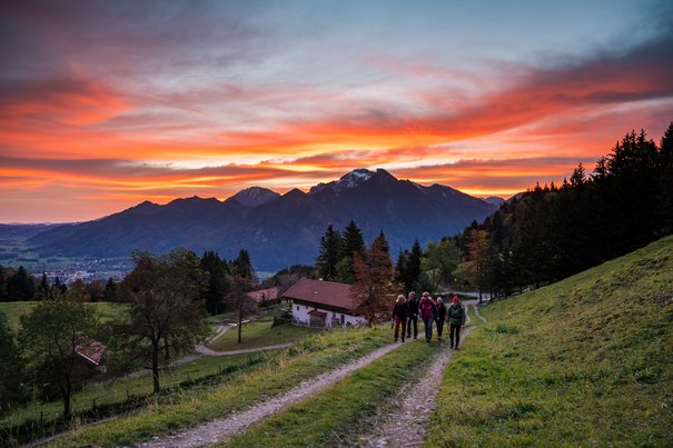 Eine Gruppe wandert bei Sonnenaufgang zur Rachalm bei Grassau