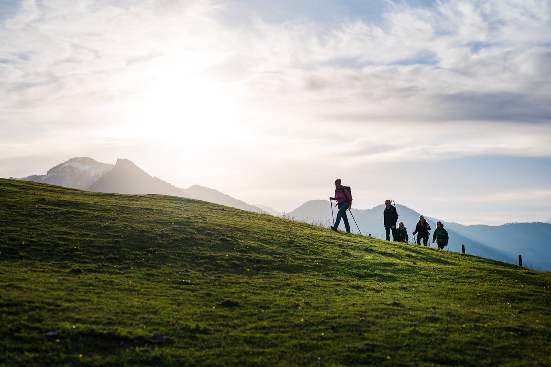 Eine Gruppe wandert bei Sonnenaufgang nahe der Rachlalm in Grassau