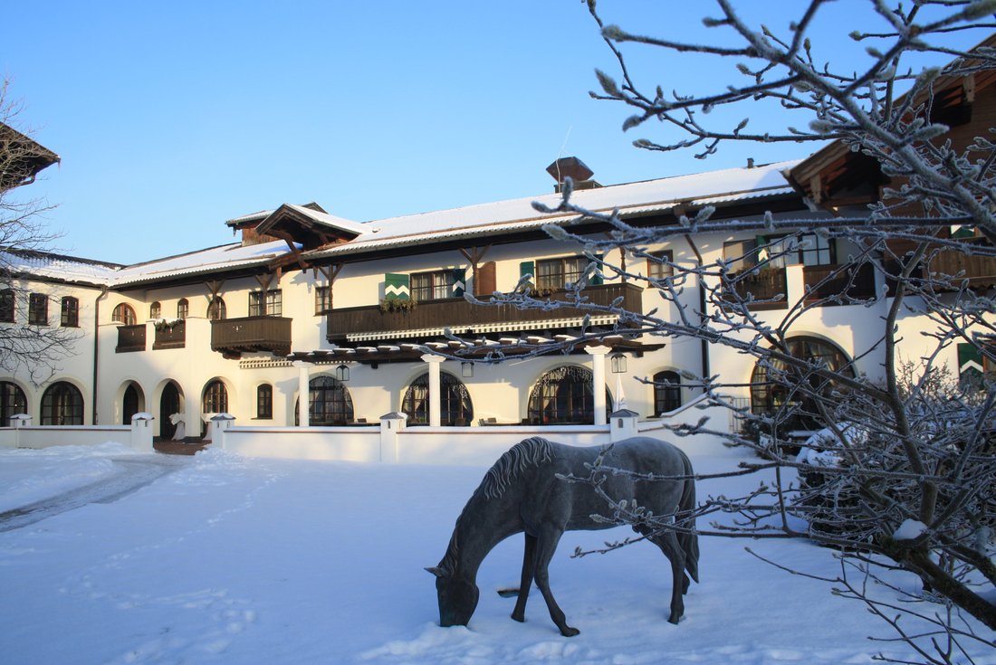 Hotel Gut Ising - Winter Außenansicht mit Pferd