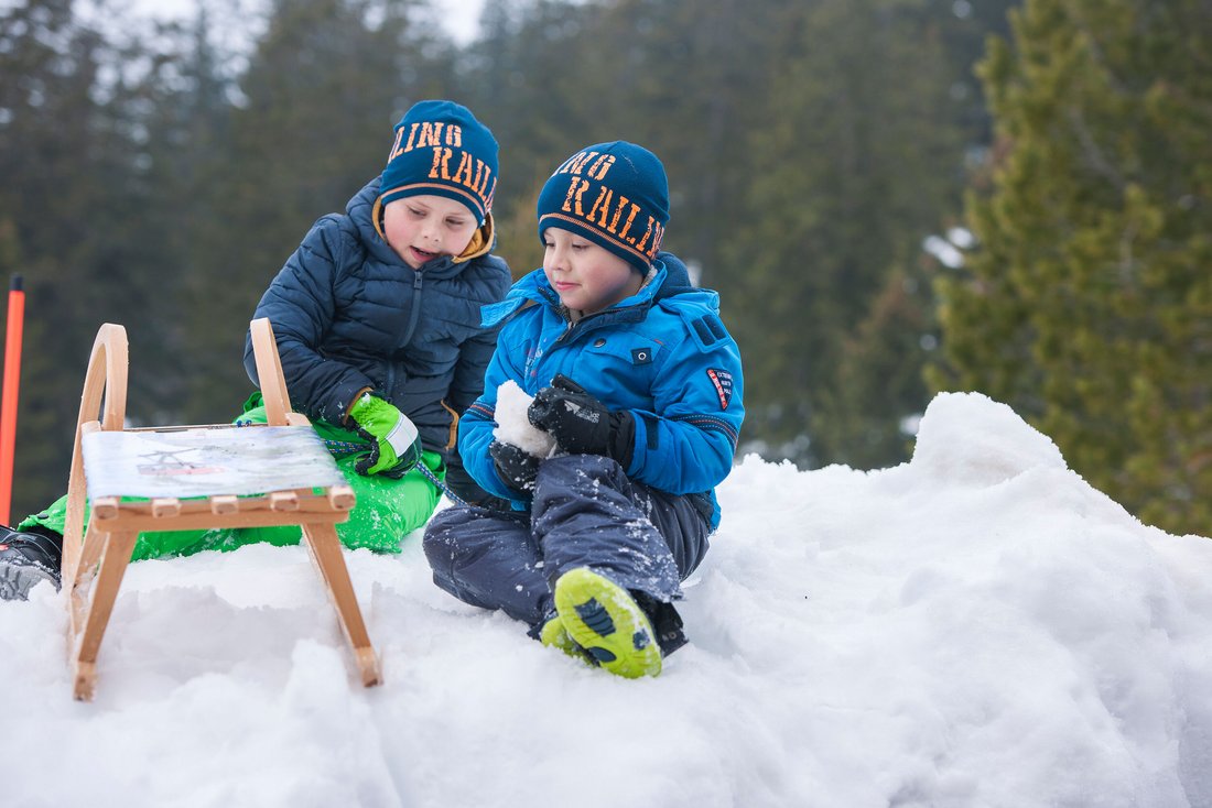 Zwei Jungs beim Rodeln im Schnee Chiemgau