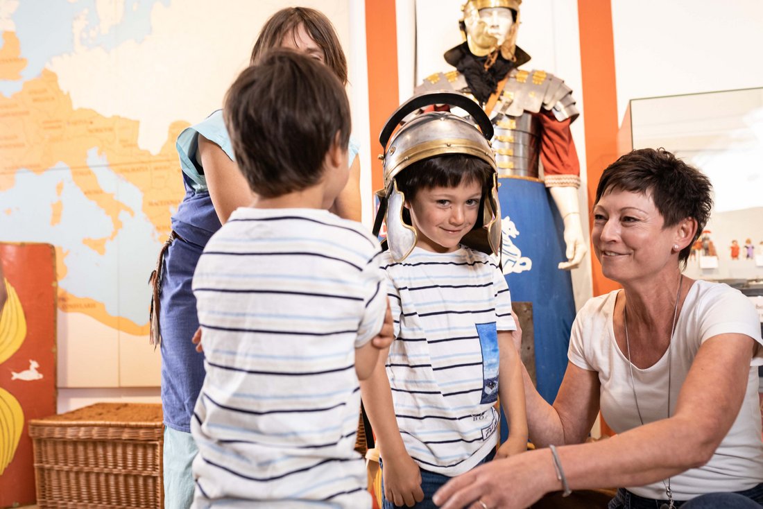 Kinder probieren den Römerhelm im Römermuseum in Seebruck