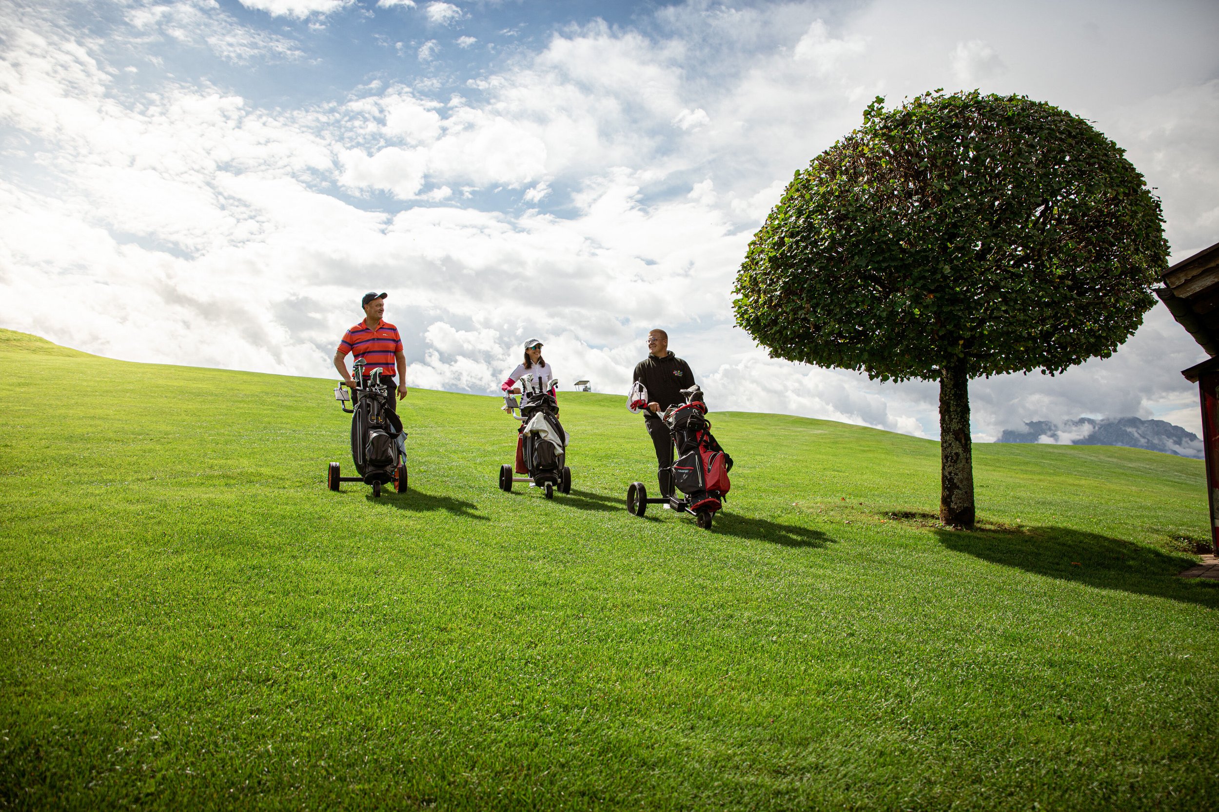 Zwei Männer und eine Frau auf dem Golfplatz Reit im Winkl während der Golfwoche Chiemsee