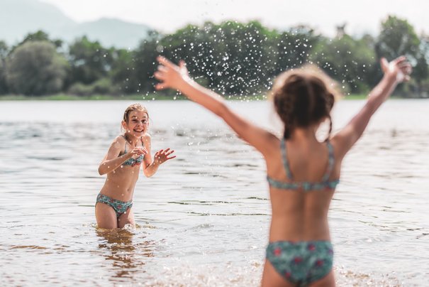 Children splash around in the Chiemsee in Übersee