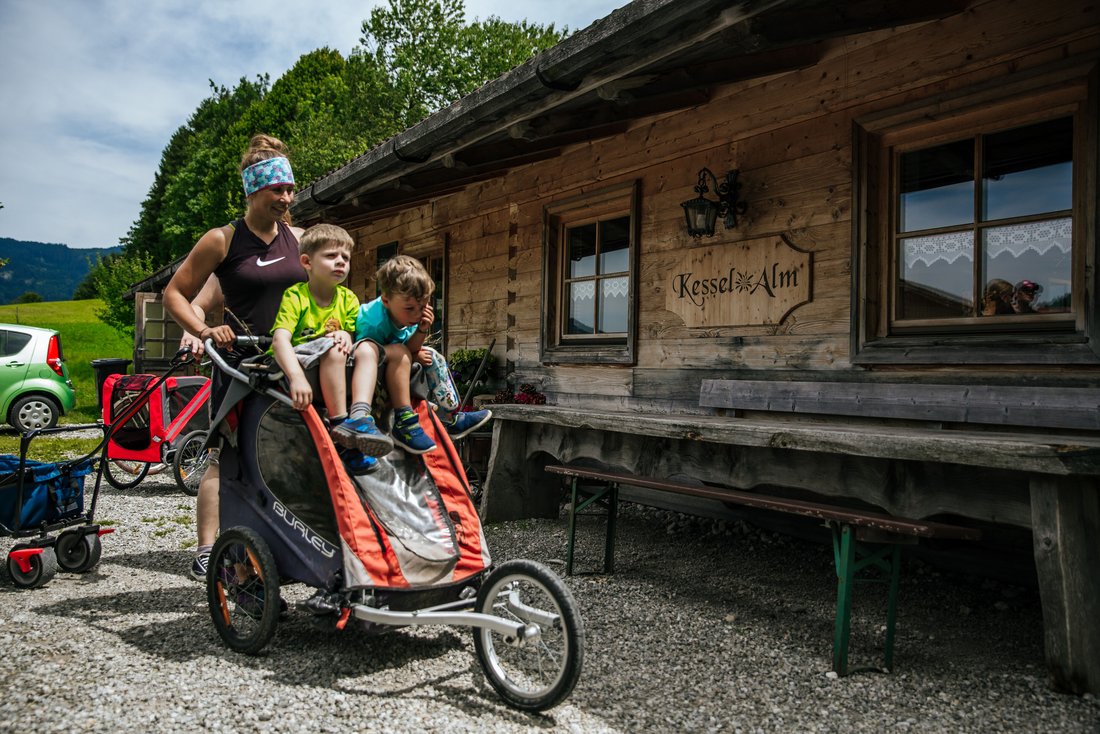 Familie mit Kinderwagen vor der Kesselalm bei Inzell im Chiemgau 