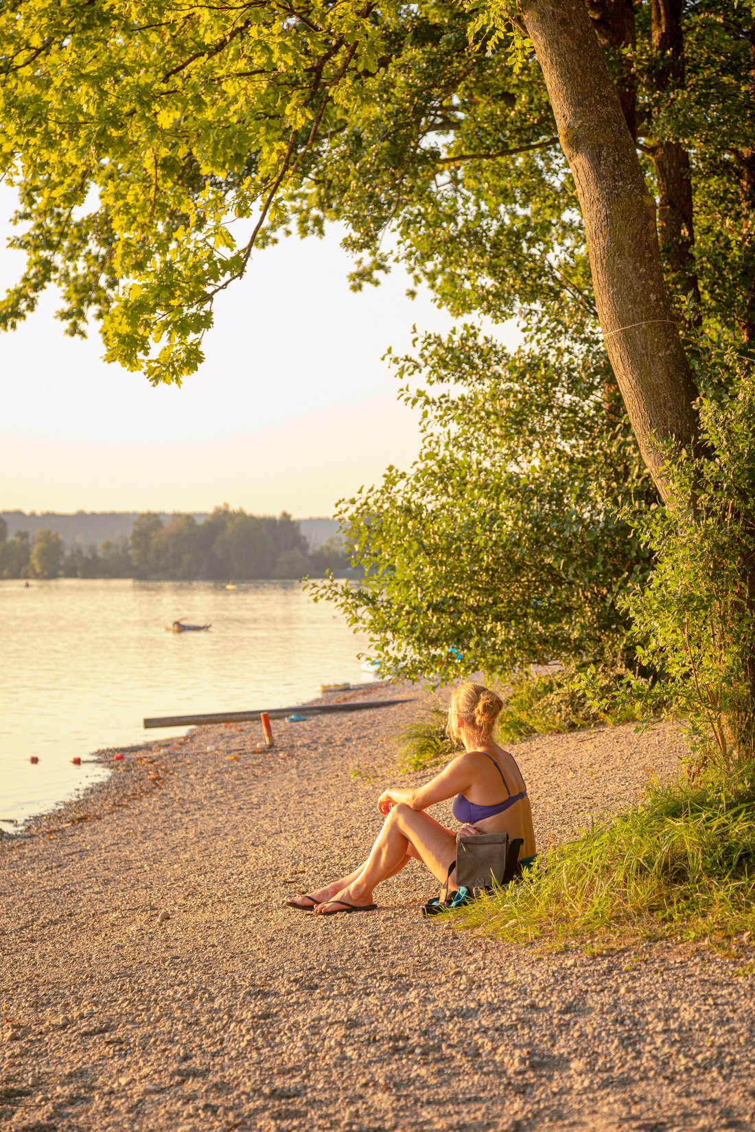 Frau sitzt am Waginger See Ufer 