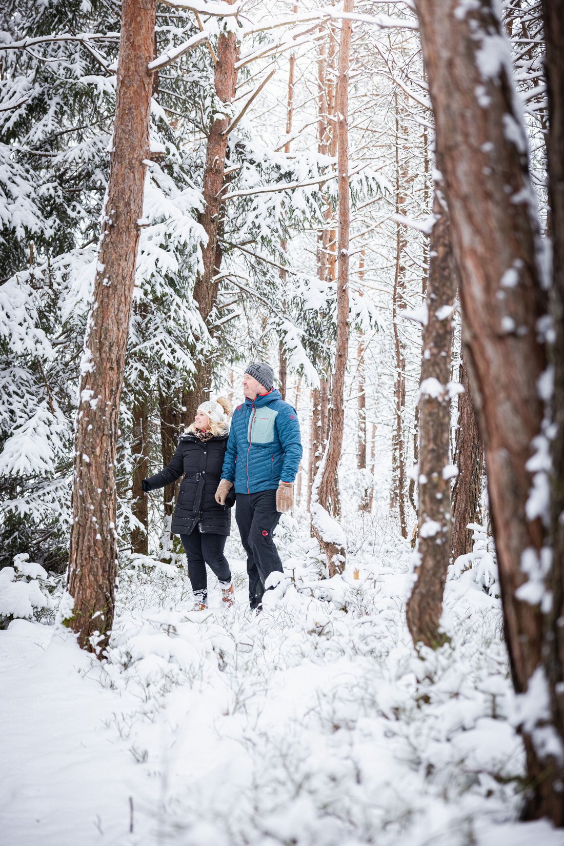 Junges Paar wandert in der verschneiten Kendlmühlfilze bei Grassau