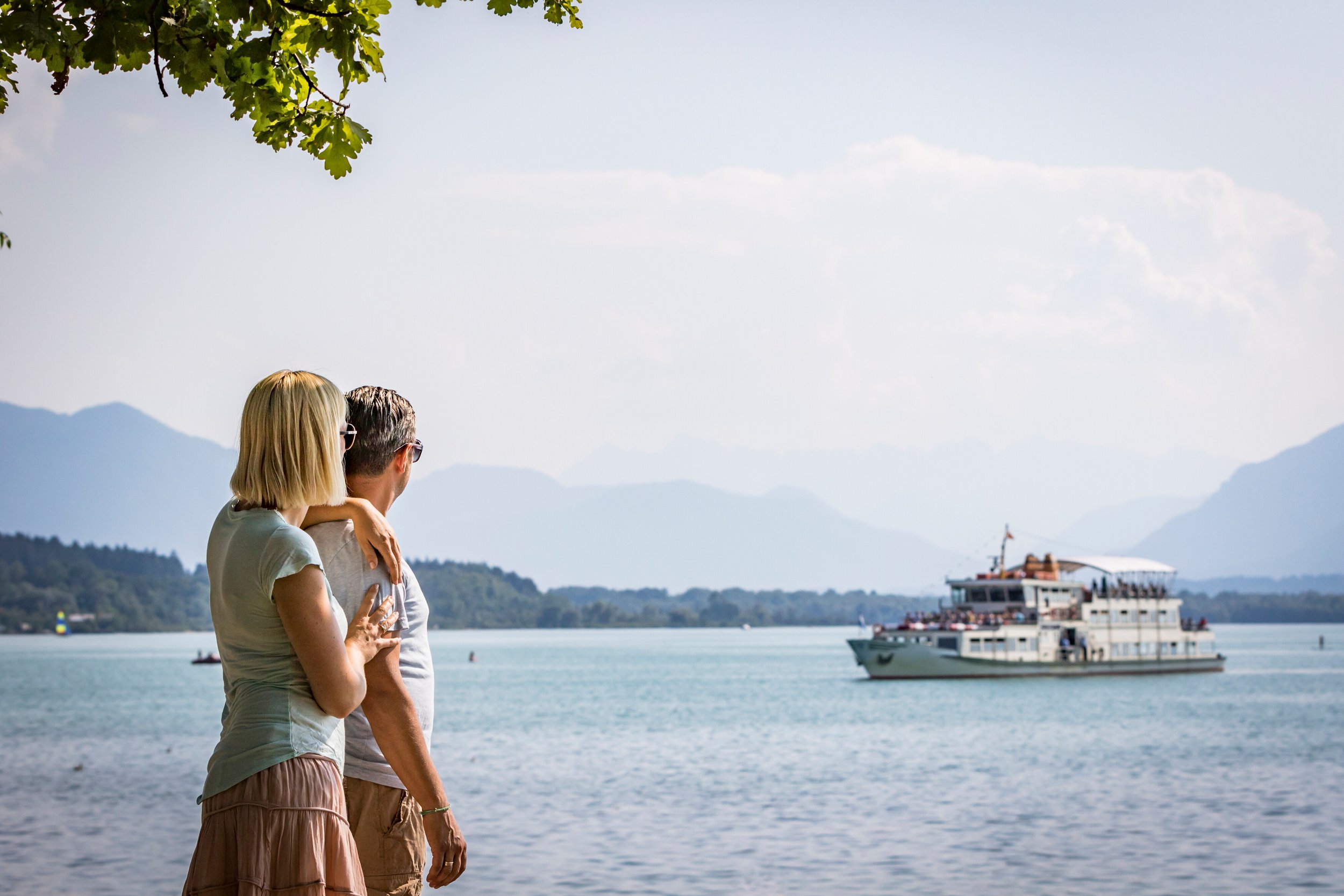 Couple looks over the Chiemsee, in the background the Chiemsee Schifffahrt