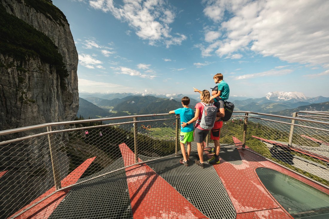 Familie betrachtet das Bergpanorama auf der Aussichtsplattform Steinplatte