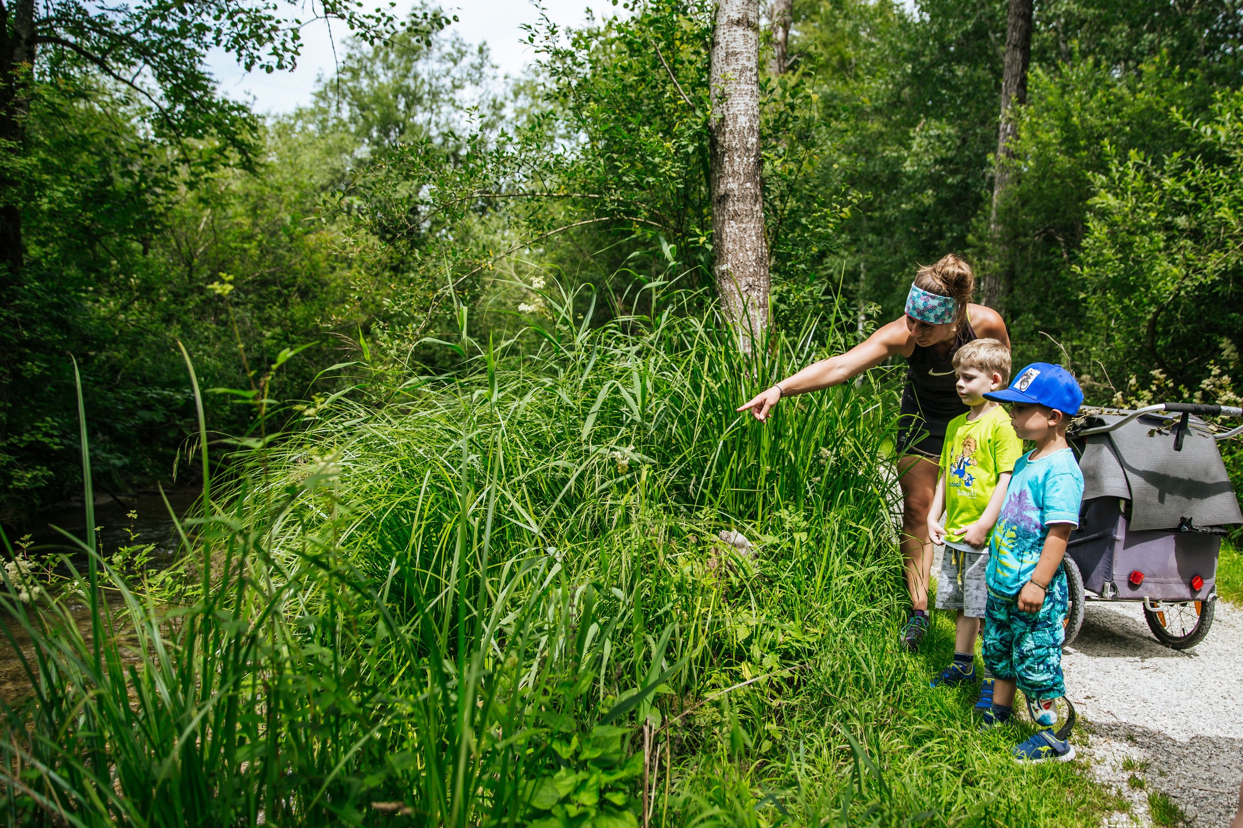Mutter erklärt ihren Kindern entlang des Wanderweges bei Inzell die Pflanzen 