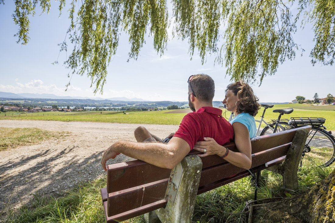 Rafahrer auf einer Bank mit Blick auf den Tachinger See und Taching am See