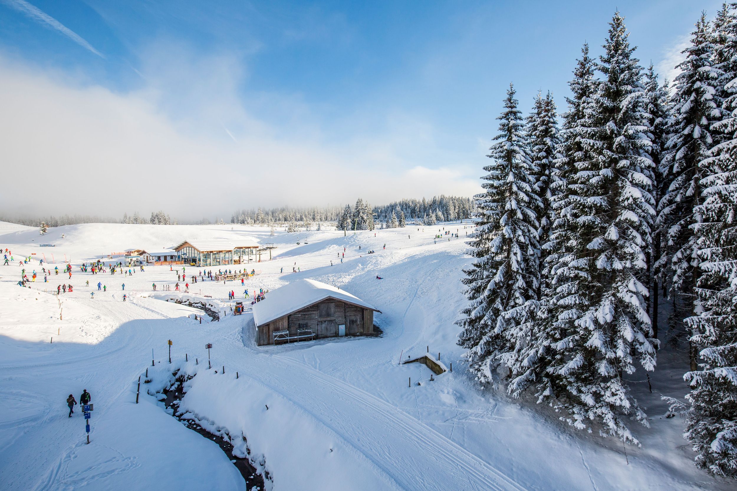 Wanderer und Skiefahrer tummeln sich um die Gondelstation bei der Winklmoosalm 