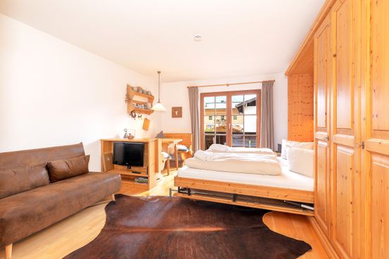 Wohnbereich mit Bett, neuem Sofa (2025) und Essbereich