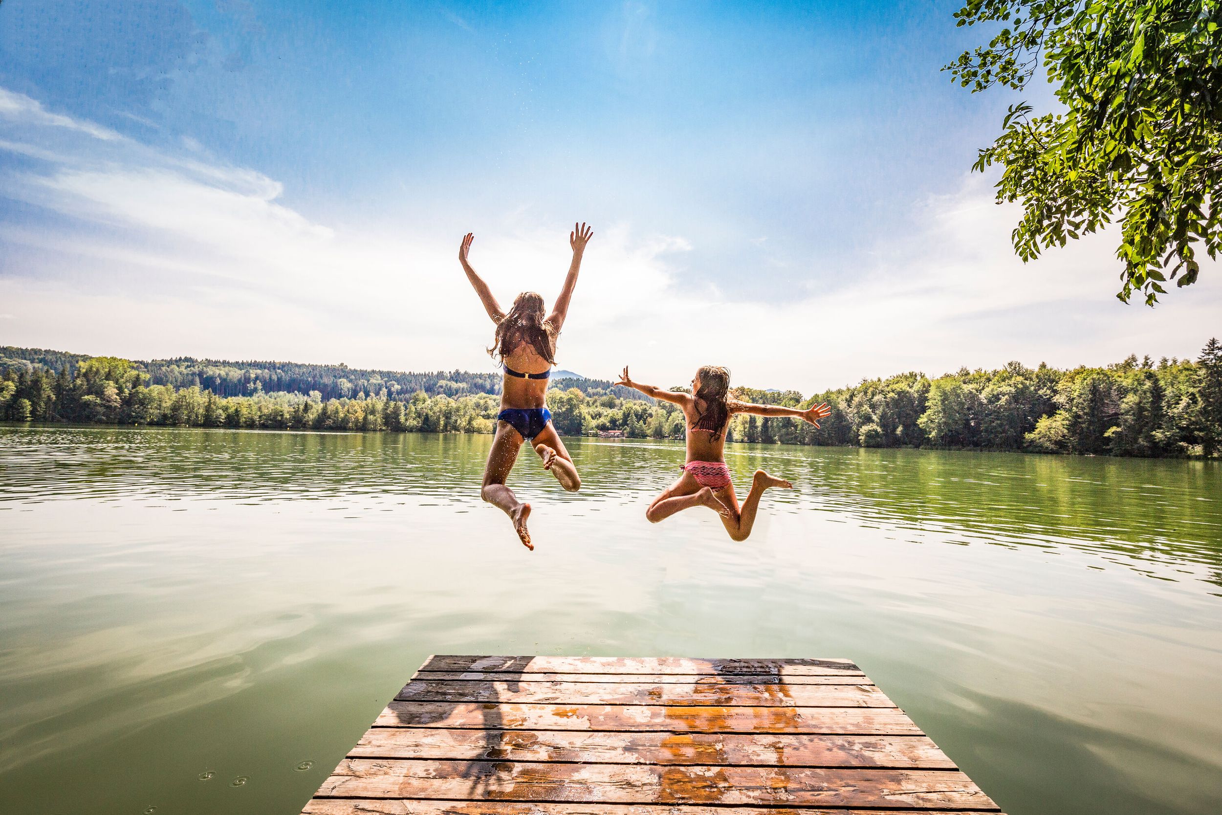 Mädchen springen vom Steg am Tüttensee ins Wasser