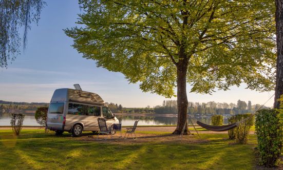 Wohnmobil auf einem Stellplatz mit Blick auf den Waginger See am Strandcamping Waging am See.