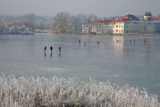 Schlittschuhläufer auf dem gefrorenen Chiemsee nahe der Fraueninsel