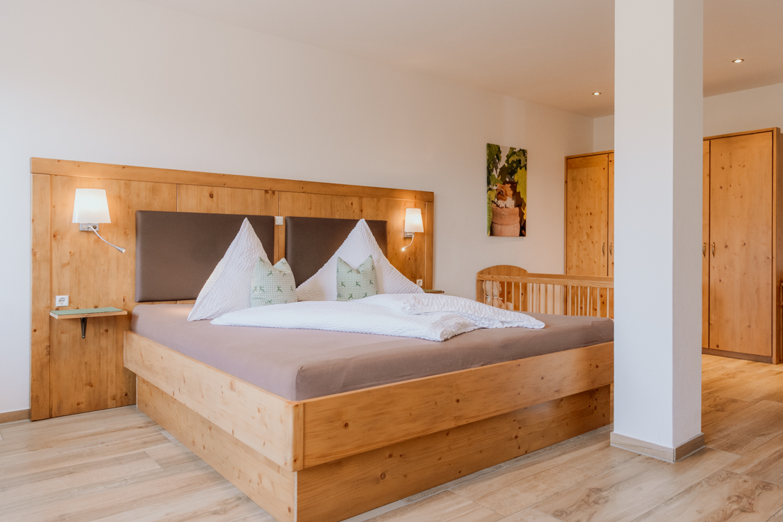 Gemütliches Schlafzimmer der Ferienwohnung Kampenwand mit Platz für bis zu drei Personen und Babybett