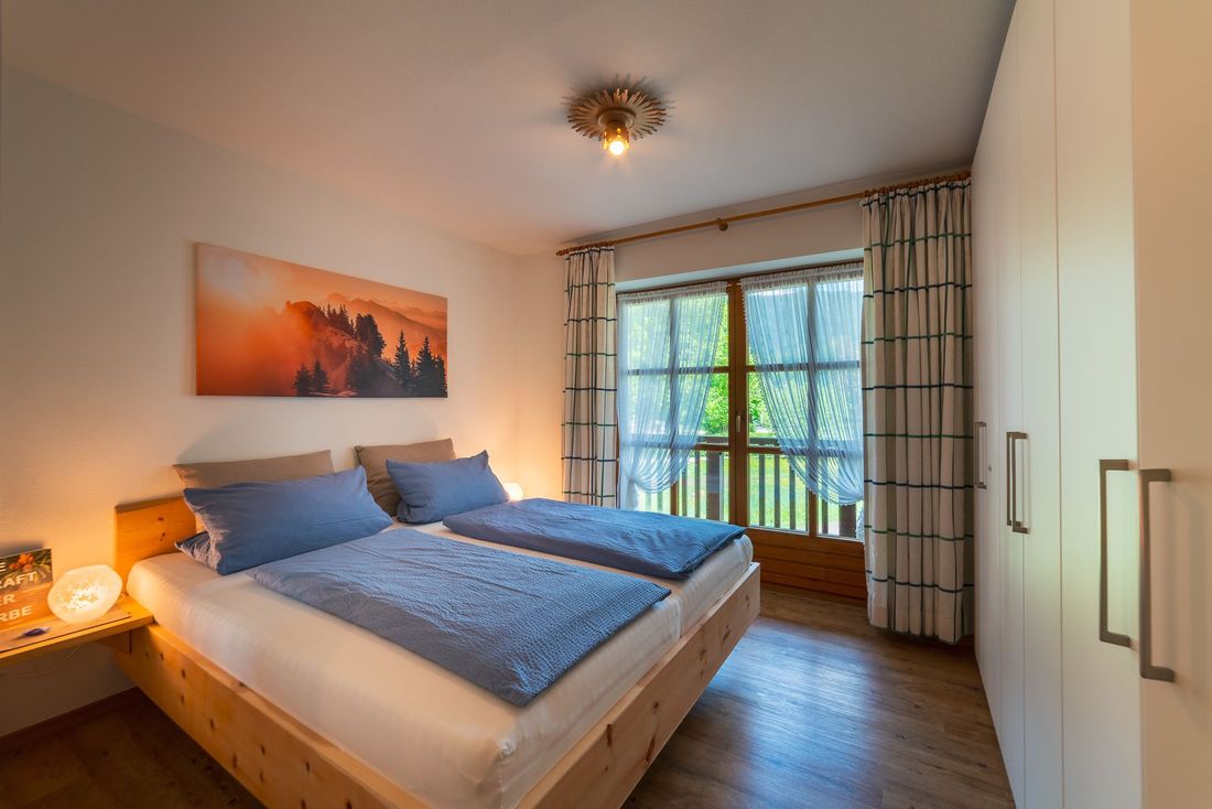 Schlafzimmer mit Zirbenbett und Balkon