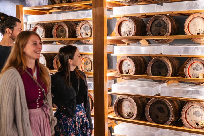 Freundesgruppe neben historischen Bierfässern vom Hofbräuhaus Traunstein bei Brauereiführung 