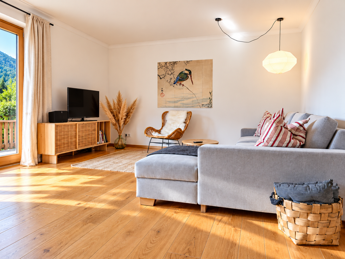 Gemütlich Wohnzimmer mit Holzbodem und Gartenblick.