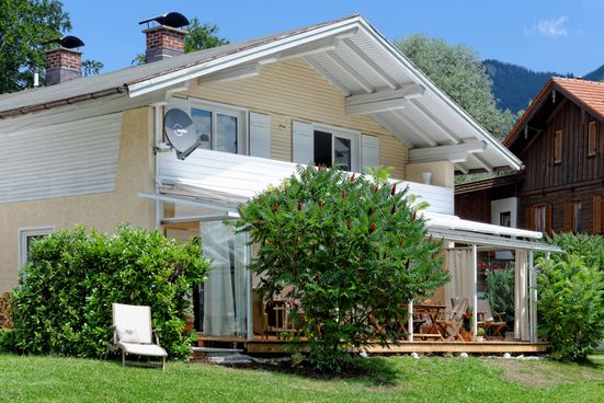 Blick vom Garten auf Haus und Wintergarten