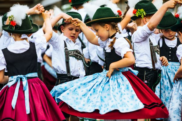 Kinder in Tracht tanzen miteinadner