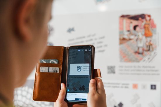 Mädchen mit Handy vor einem QR Code im Römermuseum Grabenstätt