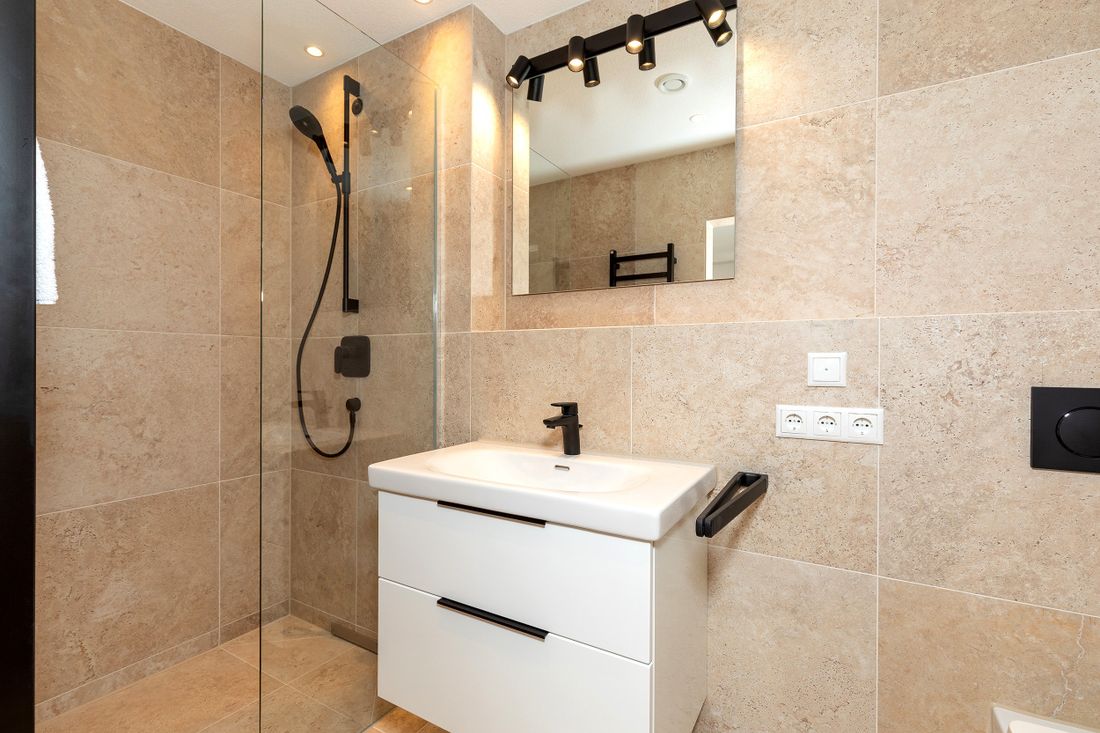 Bad en suite - mit Steinboden und ebenerdiger Dusche