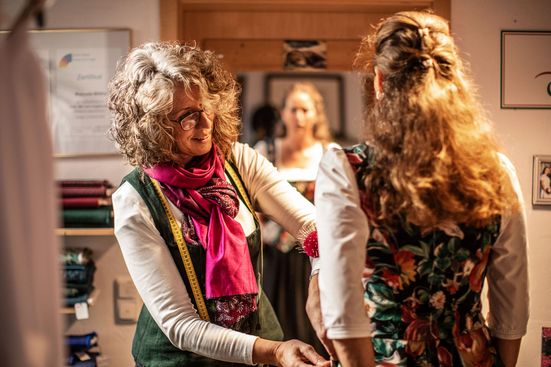 Trachtenschneiderin beim Abstecken eines Dirndlkleides 