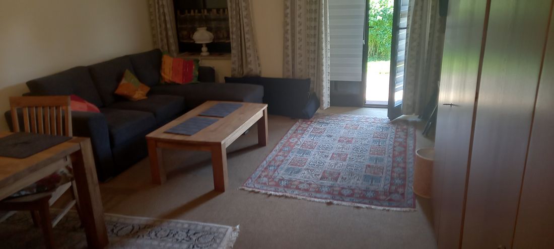 Wohn/Esszimmer mit Schlafcouch und Zugang zur Süd Terrasse