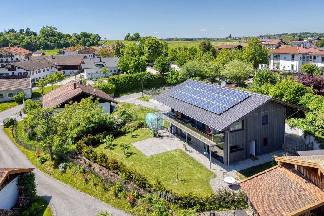 "Aussenaufnahme mit Drohe des Gartens und Terrassenbereich der nachhaltigen Ferienwohnung Liebllingseck am Chiemsee"