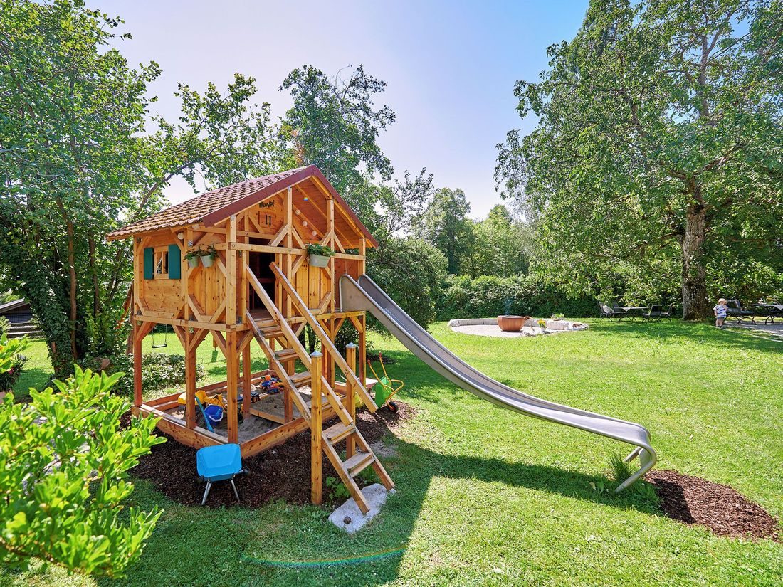Spielhaus im Garten, im Hintergrund Grillstelle