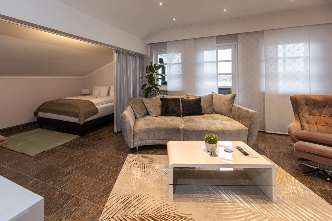 Wohnzimmer mit Balkon und separiertem Schlafbereich