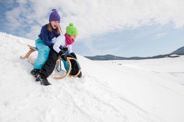Zwei Kinder beim Rodeln im Chiemgau