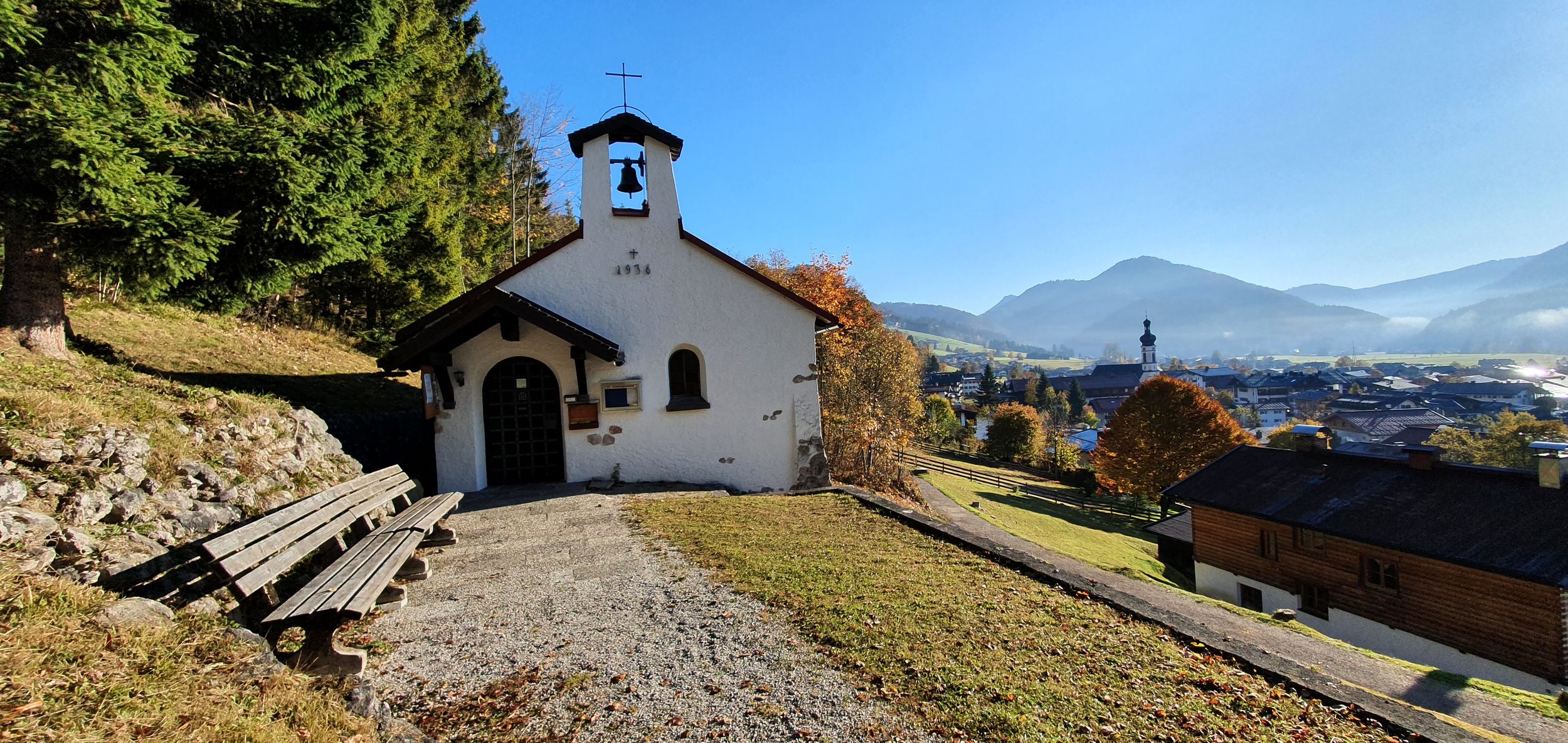 Evang. Bergkirchlein mit Dorf im Hintergrund - Herbststimmung