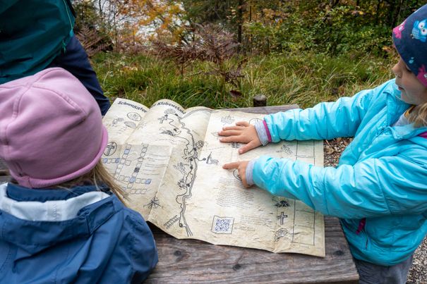 Familie schaut auf die Schatzkarte für den Schmugglerweg