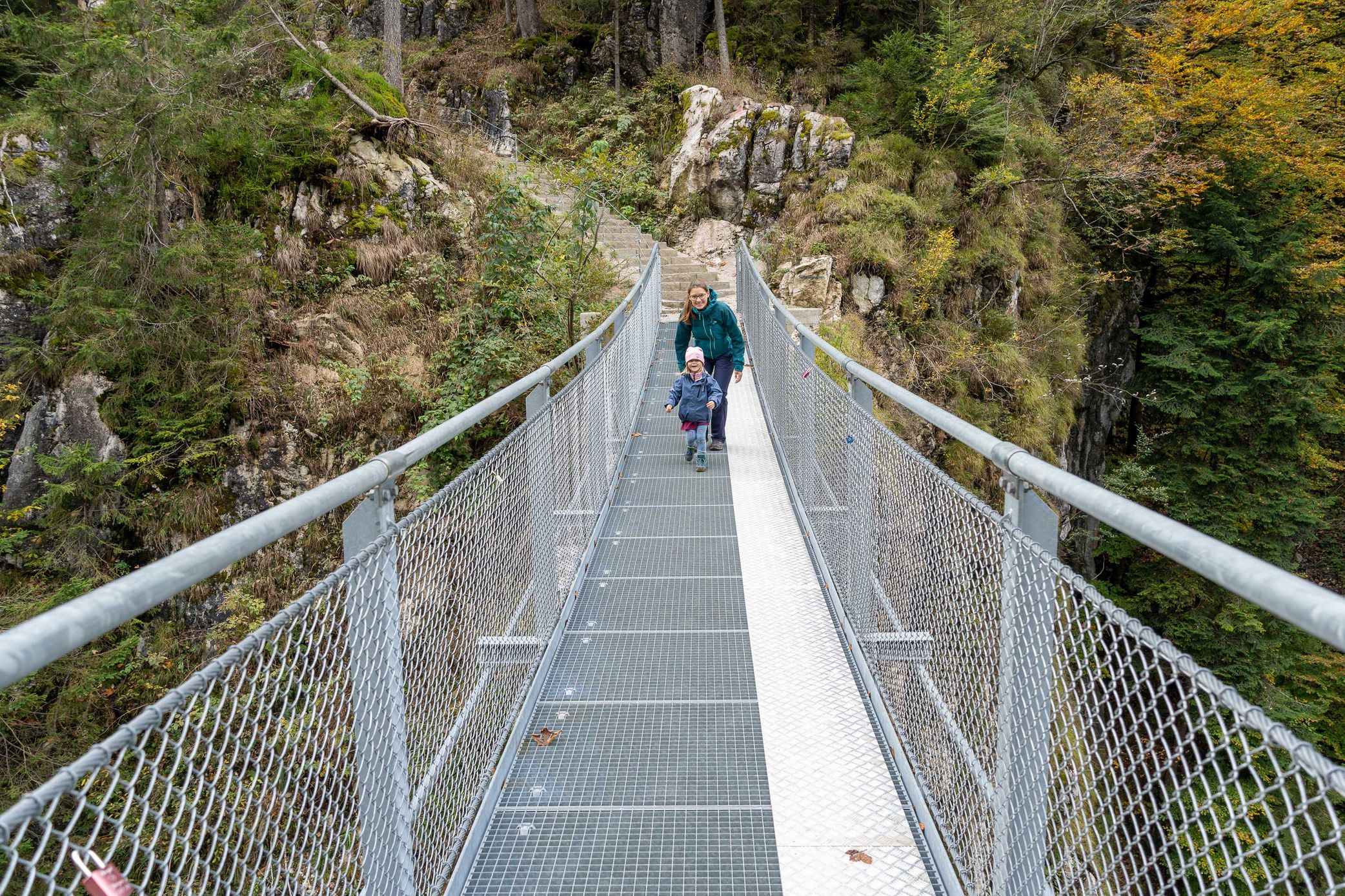 Kind läuft mit Mutter über eine Hängebrücke beim Schmugglerweg