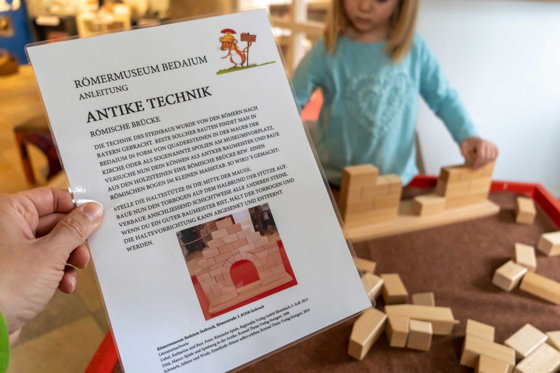 Kind baut eine römische Brück mit Bauklötzen nach