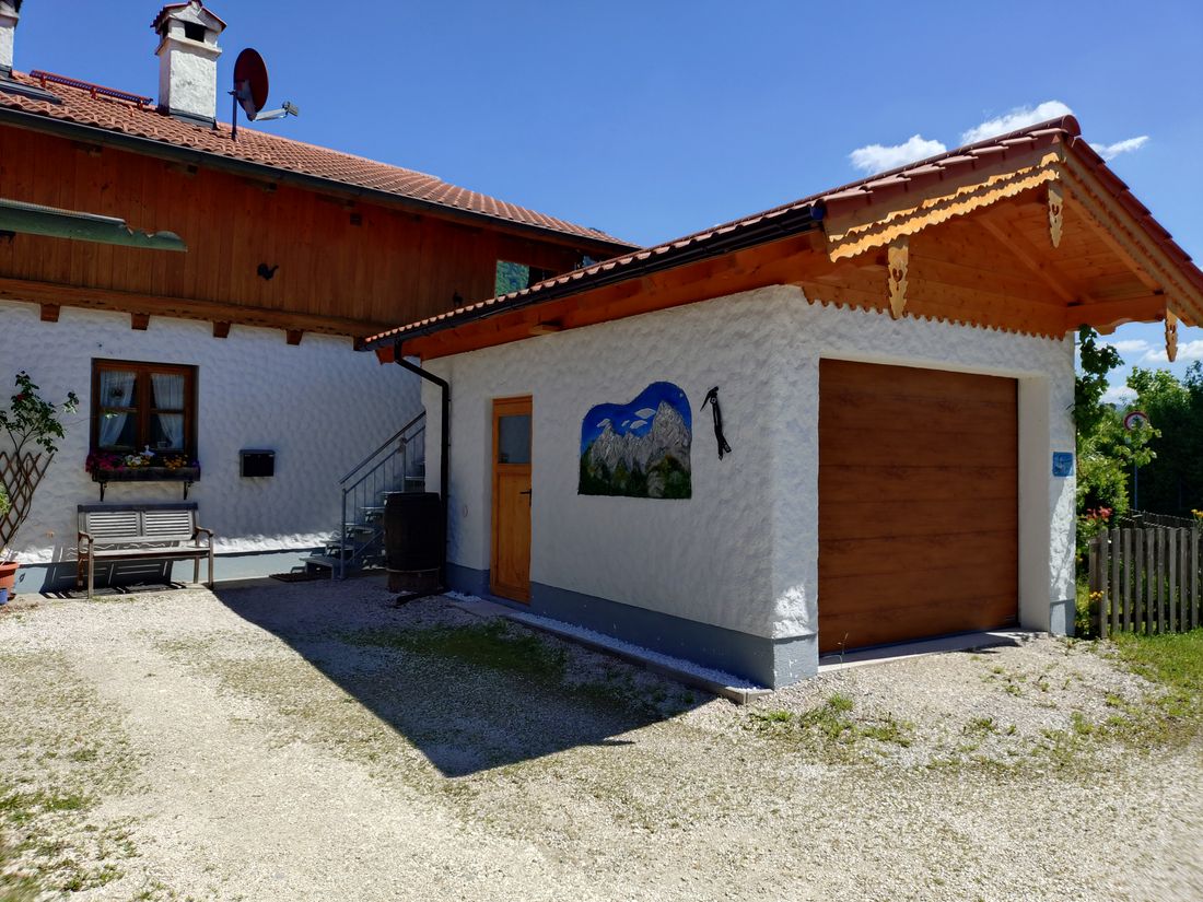 Gäste-Garage mit Elektro-Tor, Treppenaaufgang zur Ferienwohnung mit Balkon
