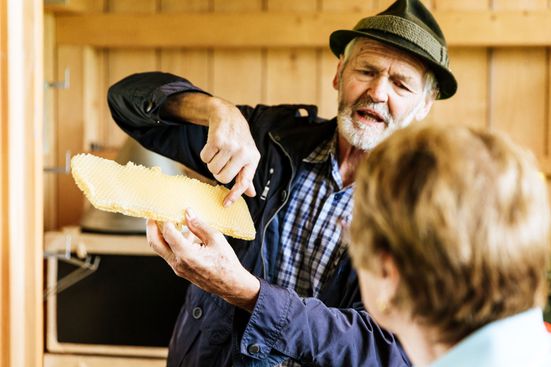 Imker Matthias mit einer Bienenwabe